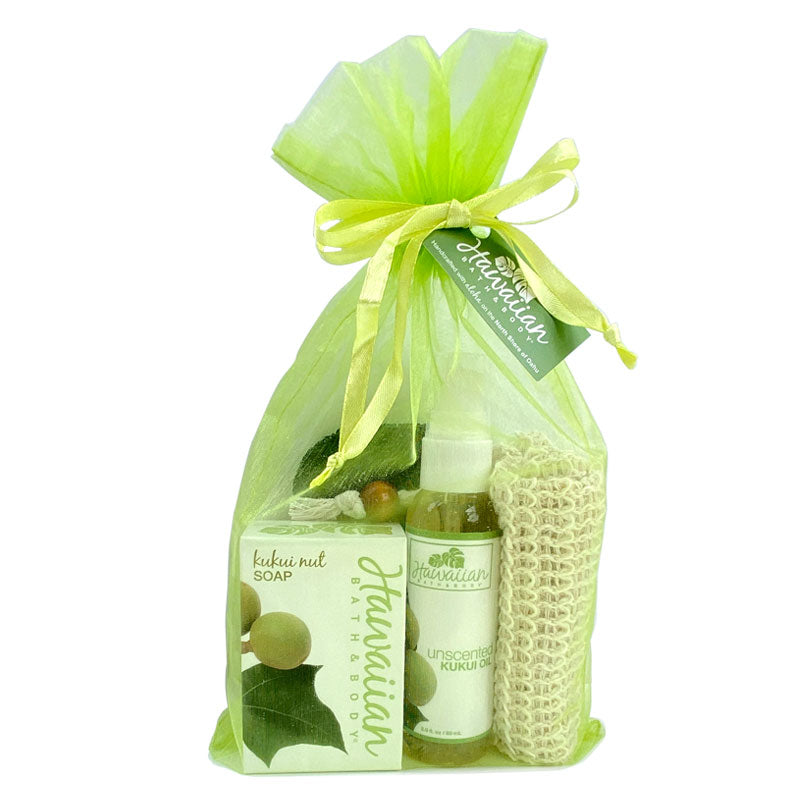 Kukui Oil Gift set with soap, lotion, and scrub in a green organza bag on a white background